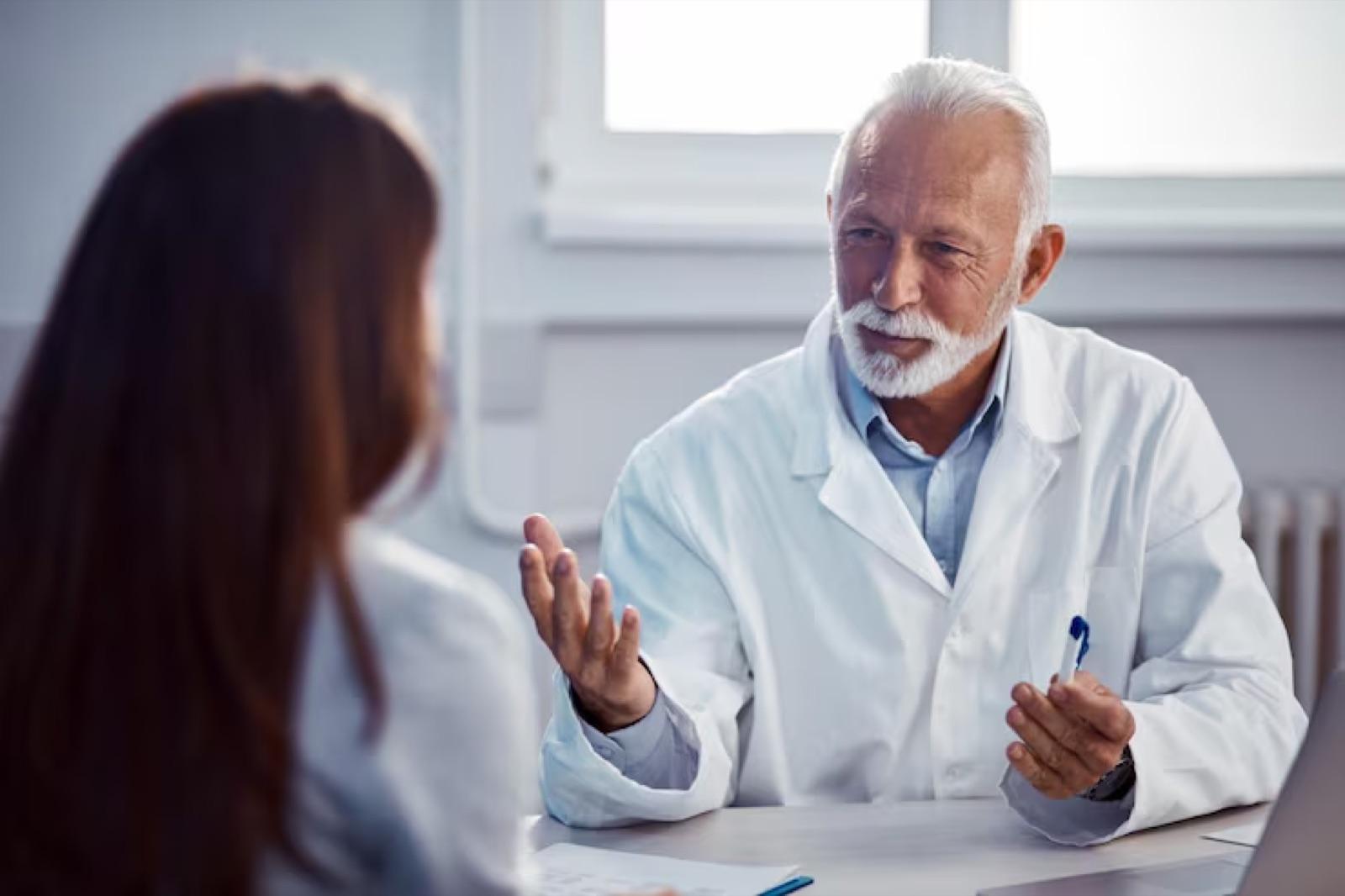 A doctor discusses results with a patient across a desk