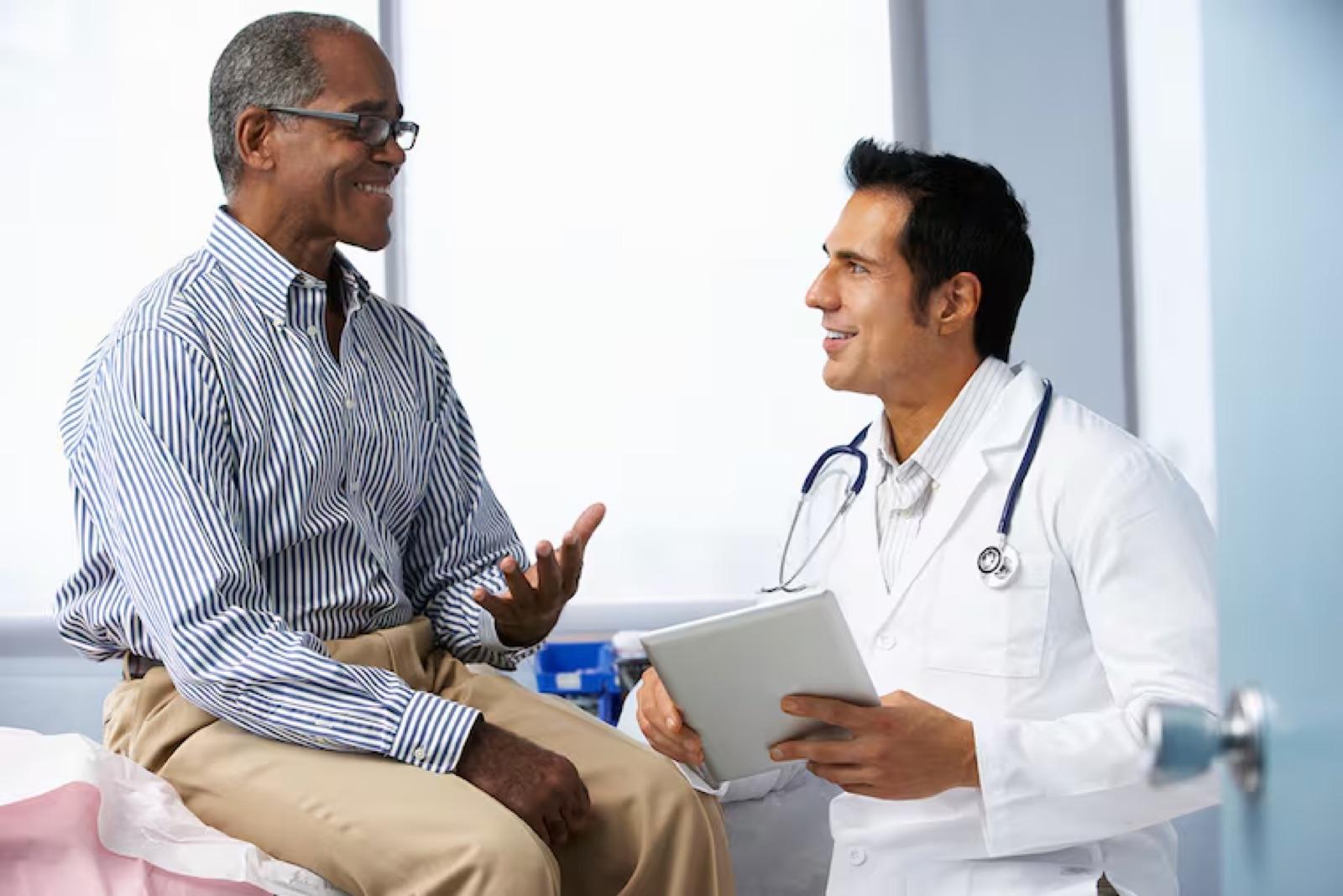 A patient talks with a doctor holding a tablet